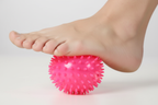 Close-up of foot using neon pink massage ball